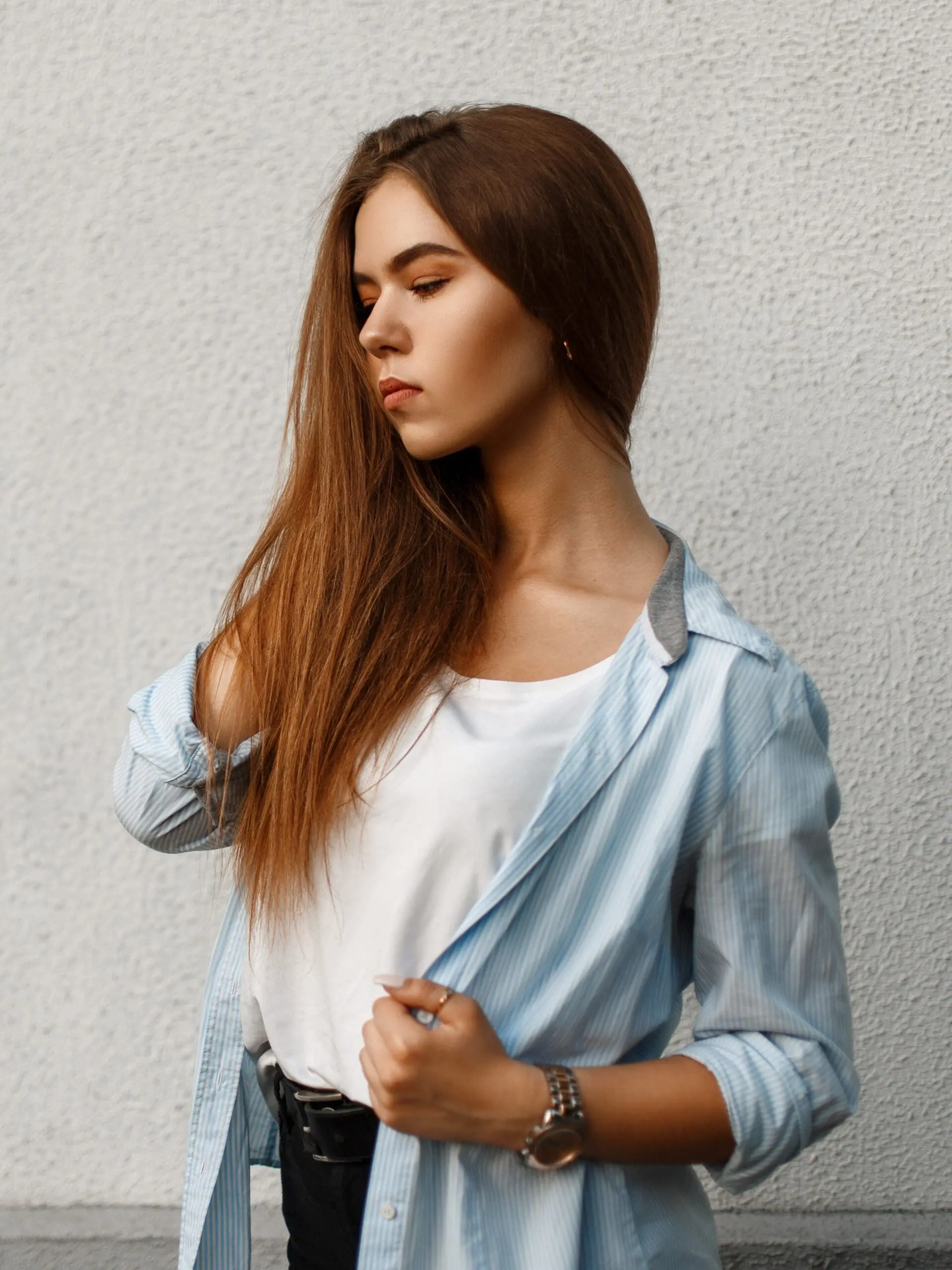 Beautiful Young Woman In A Stylish Blue Shirt In Casual Style Near A Blue Wall