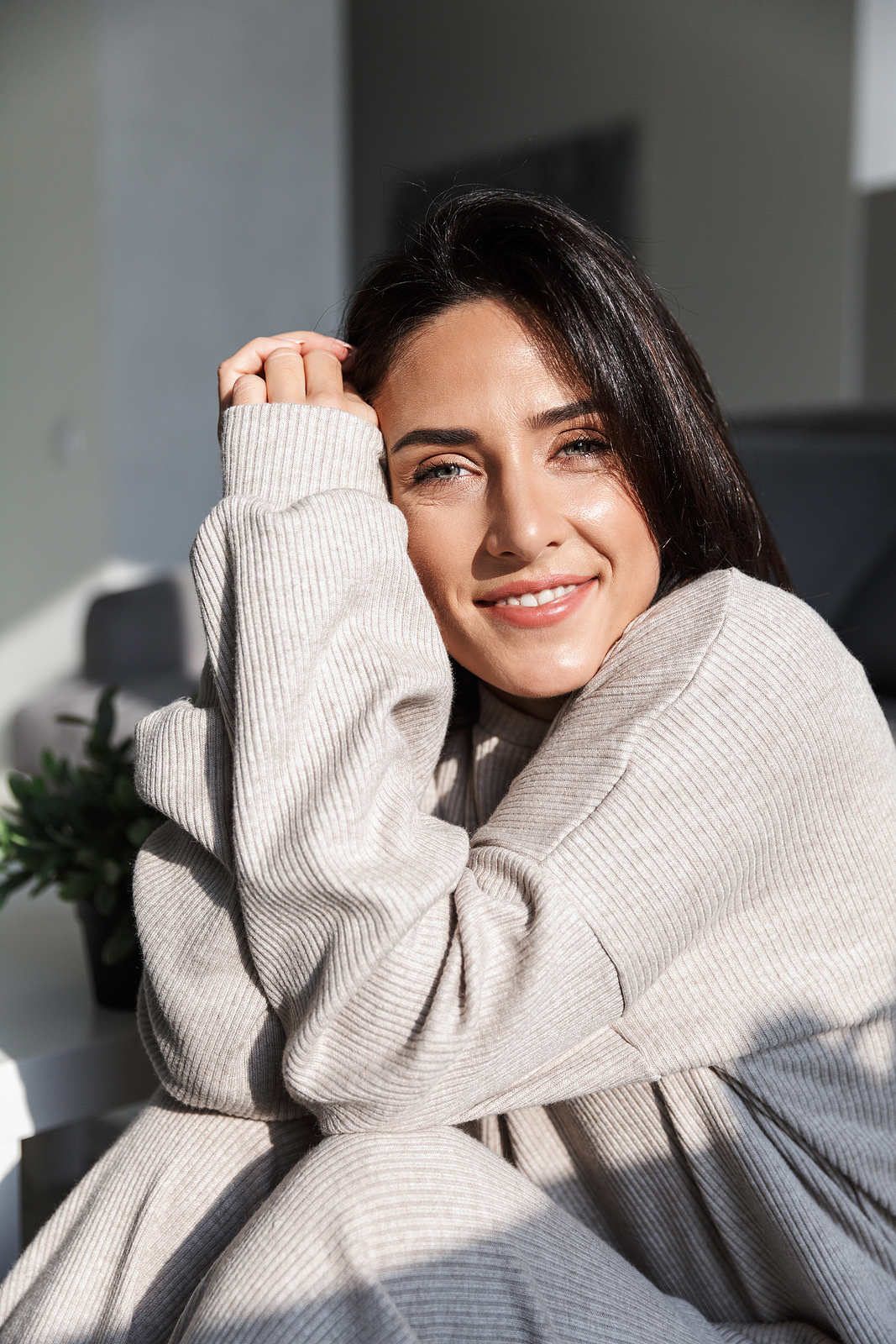 Photo of middle-aged sunlit woman 30s smiling while sitting on c