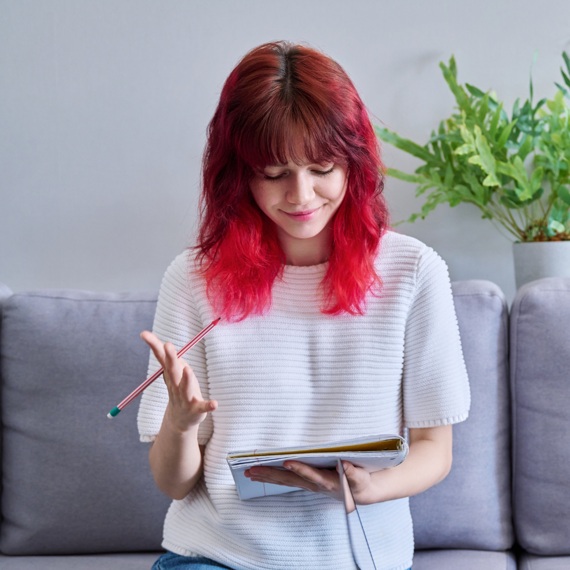 girl with red hair looking at notebook